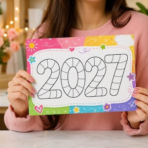 May include: A rectangular sign featuring the year 2027 in large, bold, black-outlined numbers. The background is a colourful collage of pink, yellow, green, and purple sections decorated with small illustrations of suns, clouds, hearts, and stars.