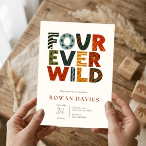 May include: A cream-colored invitation with the text "FOUR EVER WILD" in colorful, patterned letters. The invitation includes details for Rowan Davies' celebration, with the date, time, and RSVP information. The invitation is held by a person.