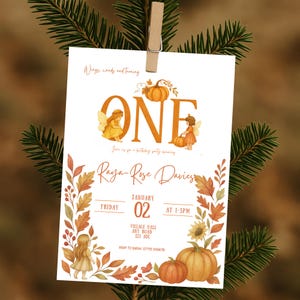 May include: A white invitation card with autumn-themed illustrations and text. The card features the word "ONE" in large orange letters, along with the name "Raya-Rose Davies" and event details. Pumpkins, leaves, and fairy illustrations decorate the card.