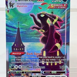 Op de afbeelding: Een holografische Umbreon VMAX Pokémon-kaart. De kaart toont een donkerpaars Umbreon-personage met gele accenten tegen een kleurrijke achtergrond. De kaart heeft tekst, waaronder "Dark Signal" en "Max Darkness".