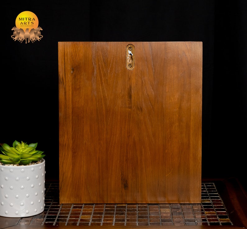 K&ouml;nnte beinhalten: Ein Wandregal aus Holz mit brauner Oberfl&auml;che. Das Regal hat ein schlichtes Design und ist bereit zum Aufh&auml;ngen an einer Wand.