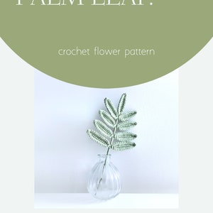 May include: A crocheted green palm leaf in a clear glass vase. The leaf is made with a delicate stitch pattern and has a natural, organic look. The vase is simple and elegant, and the overall image is calming and serene. The text "PALM LEAF. crochet flower pattern" is at the top of the image. The text "breathe." is at the bottom left of the image. The text "@breathe.workshop" is at the bottom right of the image.