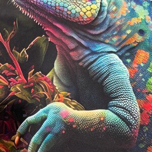 May include: A close-up of a colourful chameleon with iridescent scales. The chameleon's eye is blue and its body is a mix of green, blue, and purple. The chameleon is perched on a branch with green leaves and red flowers.