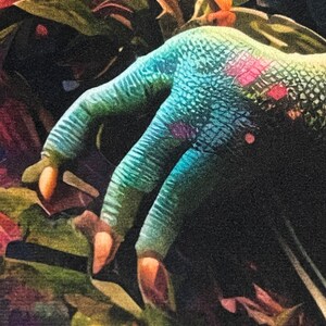 May include: A close-up of a blue hand with a scaly texture, reaching out from a background of green and red foliage.