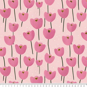 以下が含まれることがあります： 濃い緑色の茎と黄色の中心部を持つ、様式化されたピンクのチューリップの繰り返し模様が描かれた薄いピンクの生地。下端には白いメジャーが見え、1から29までのセンチメートル単位の目盛りが表示されています。