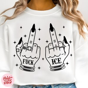 Peut inclure: Sweat-shirt blanc avec un motif noir de deux mains faisant un doigt d'honneur. Le mot "FUCK" est imprim&eacute; sous une main et "ICE" sous l'autre. Les mains ont des ongles noirs et sont orn&eacute;es de bagues.