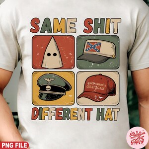 May include: A white t-shirt with the text "SAME SHIT DIFFERENT HAT" in a retro font. The shirt features four images of hats: a KKK hood, a Confederate flag hat, a Nazi cap, and a "Make America Great Again" hat.
