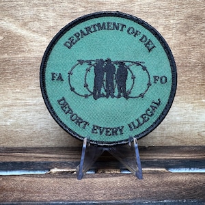 May include: Green embroidered patch with black text that reads "Department of DEI, FA, FO, Deport Every Illegal". The patch features a black silhouette of three people standing behind barbed wire.