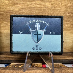 May include: A blue and black embroidered patch with a shield and two swords. The shield has a cross on it and the text "Full Armor of God" and "Eph 6:11".