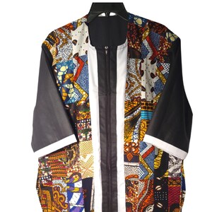 May include: A long-sleeved, black and white patterned jacket with a zipper closure. The jacket has a patchwork design with various colors and patterns, including red, orange, yellow, blue, and green.