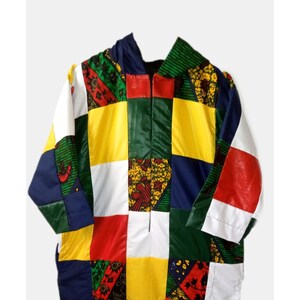 May include: A colourful patchwork hooded jacket with a zip closure. The jacket is made of different fabrics in shades of red, yellow, green, blue, and white.