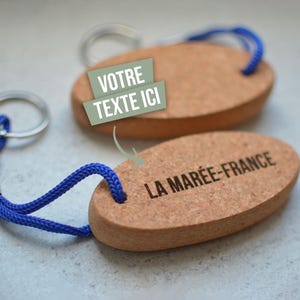 Peut inclure: Deux porte-clés en liège avec un cordon bleu. Un porte-clés dit "LA MARÉE-FRANCE" et l'autre dit "VOTRE TEXTE ICI".