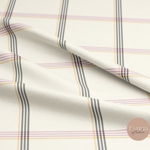 May include: White fabric with a plaid pattern in black, pink, and yellow stripes. The fabric is folded and draped.