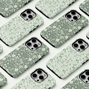 May include: Multiple phone cases with a green and white floral pattern. The cases are arranged in a grid pattern on a white surface.
