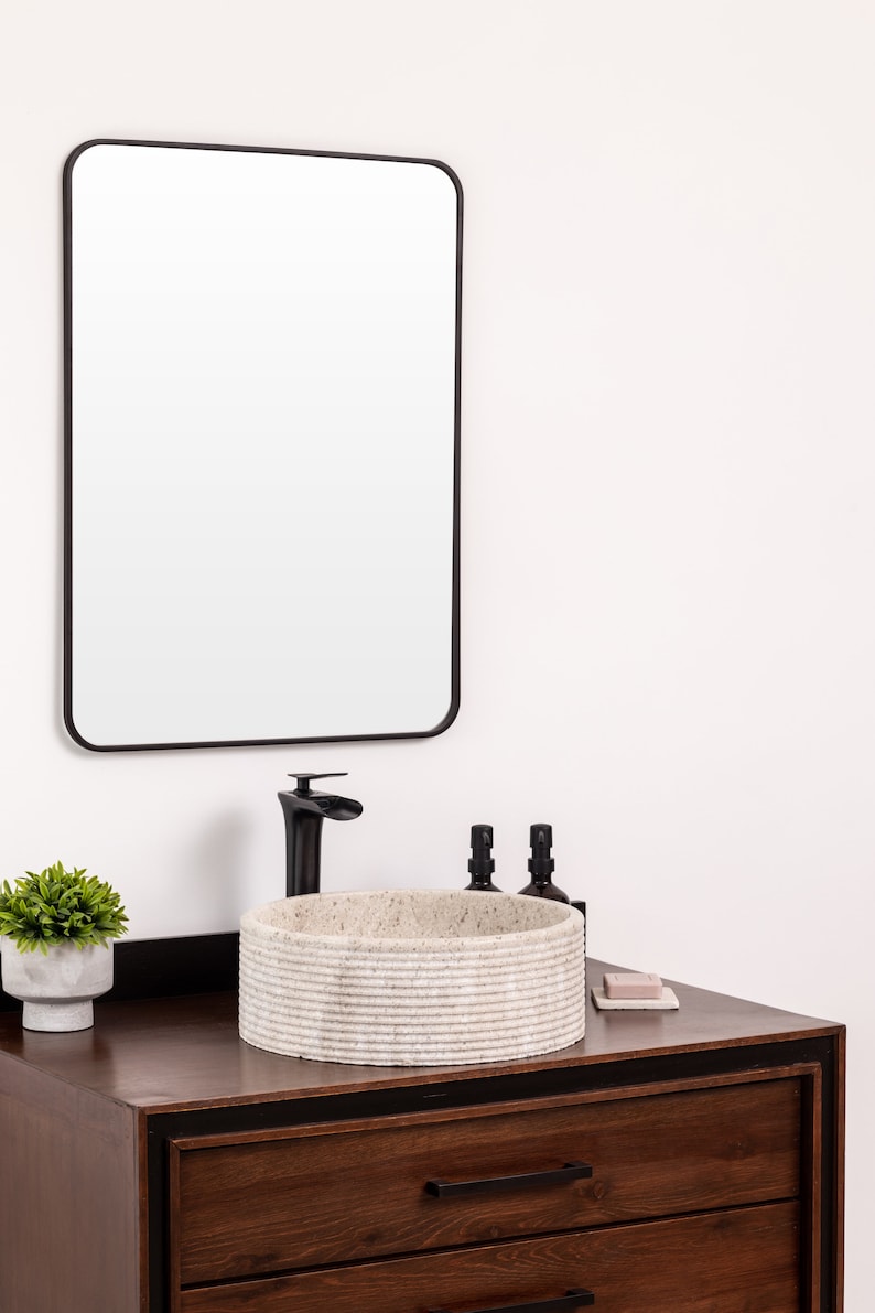 Round fluted marble vessel sink in light beige stone with polished interior