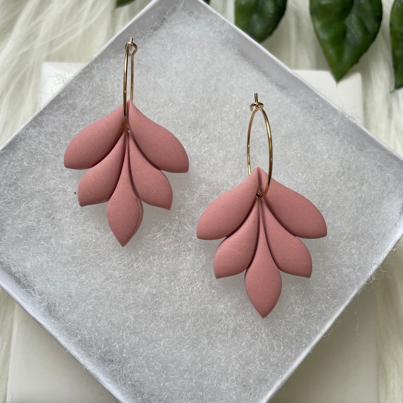Mauve pink flower leaf polymer clay earrings attached to a25mm gold plated hoop nestled in a white gift box