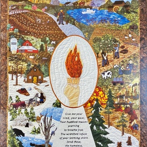May include: A handcrafted quilt with a detailed landscape scene and a central oval featuring a torch. The quilt includes a poem with the words "Give me your tired, your poor..." and depicts farms, a lake, and various animals.