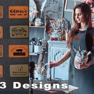 May include: A collection of 10 brown leather patches with various designs and text. The patches feature designs such as a chef's hat, a pig, a cupcake, and a mountain scene. The text on the patches includes "Robert Master Chef", "Olivia's Peace Love Art", "Grill Master Johnny", "Mom's Kitchen Cook with Love", "Olivia's Sweet Shoppe", and "Mia's Kitchen Open 24 Hours".
