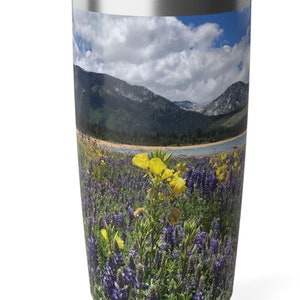 May include: A stainless steel tumbler with a colorful image of a mountain lake surrounded by a field of purple and yellow wildflowers.