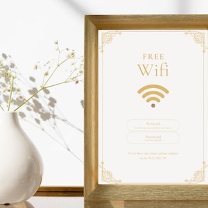 May include: A gold framed sign with the words "FREE Wifi" in a decorative font. The sign also includes a wifi symbol and instructions for connecting to the network.