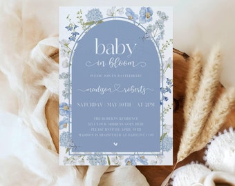 Może przedstawiać: Zaproszenie na baby shower w kolorze niebieskim i białym z kwiatową ramką i tekstem "baby in bloom" oraz "madison & roberts". Zaproszenie zawiera również datę i godzinę baby shower, a także adres i informacje RSVP.