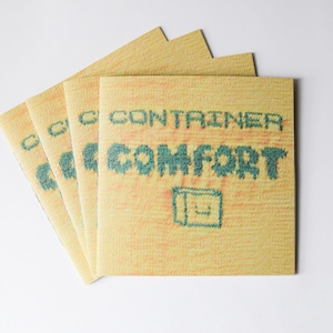 May include: A stack of four yellow paperbacks with the text "CONTAINER COMFORT" in green lettering. The cover has a pixelated design.