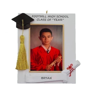 May include: A white graduation frame with a photo of a person in a red graduation gown. The frame includes a black mortarboard, a gold tassel, and a scroll. The text "FOOTHILL HIGH SCHOOL CLASS OF "YEAR"" is printed at the top, and "BRYAN" is printed at the bottom.