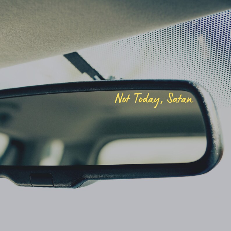 May include: A rearview mirror with the text "Not Today, Satan" written in yellow on the reflective surface.