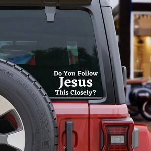 May include: A red car with a white vinyl sticker on the back window that reads "Do You Follow Jesus This Closely?"