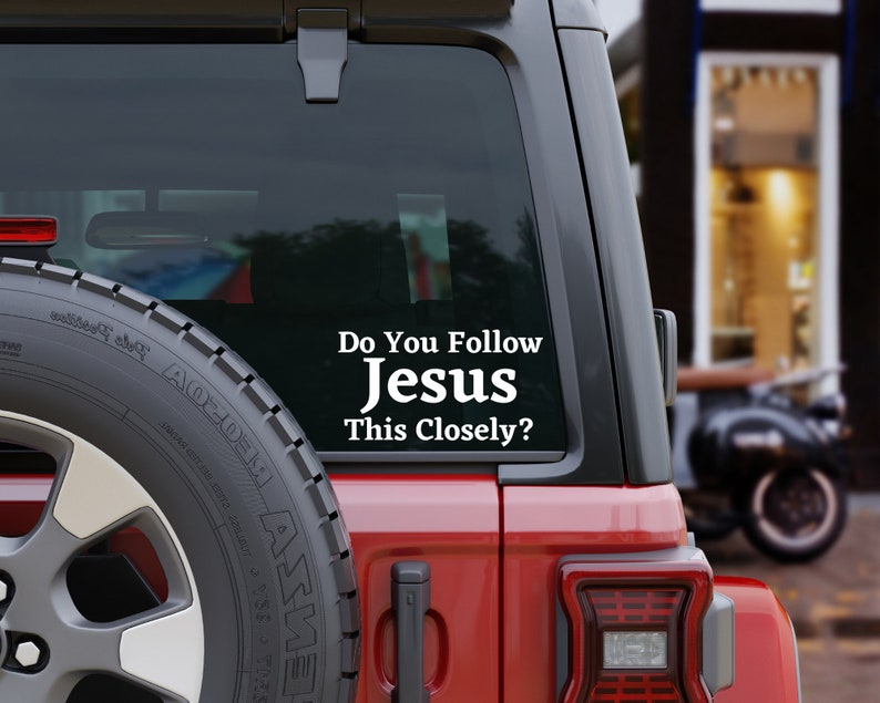 May include: A red car with a white vinyl sticker on the back window that reads "Do You Follow Jesus This Closely?"
