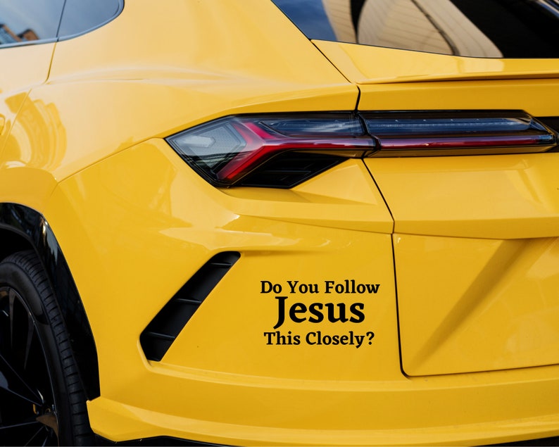 Puede incluir: Un coche amarillo con una pegatina negra en el parachoques que dice "Do You Follow Jesus This Closely?"