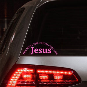 Puede incluir: Un coche plateado con una pegatina rosa en la ventana trasera que dice "The Way, The Truth, The Life, Jesus".