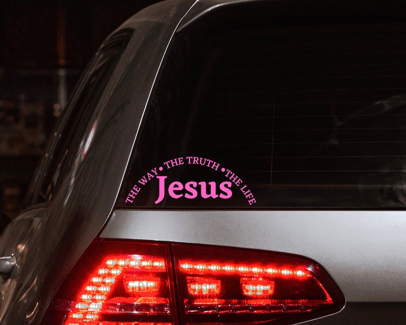 Puede incluir: Un coche plateado con una pegatina rosa en la ventana trasera que dice "The Way, The Truth, The Life, Jesus".