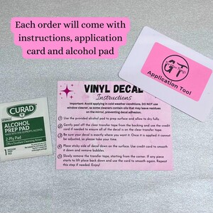 K&ouml;nnte beinhalten: Ein Bild mit einer rosa Anleitungskarte f&uuml;r Vinyl-Aufkleber, einem Alkoholtupfer und einem rosa Applikationswerkzeug. Die Karte enth&auml;lt Anweisungen zum Anbringen von Aufklebern, einschlie&szlig;lich der Verwendung des Alkoholtupfers zur Oberfl&auml;chenvorbereitung.