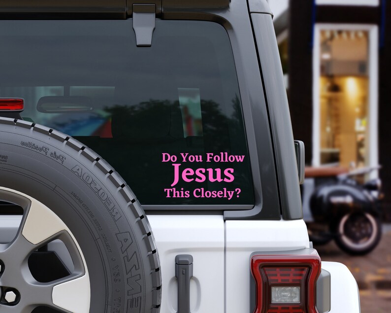 May include: A white car with a pink vinyl sticker on the back window that says "Do You Follow Jesus This Closely?"