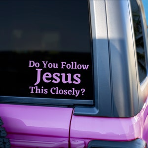 May include: A pink Jeep with a sticker on the back window that reads "Do You Follow Jesus This Closely?"
