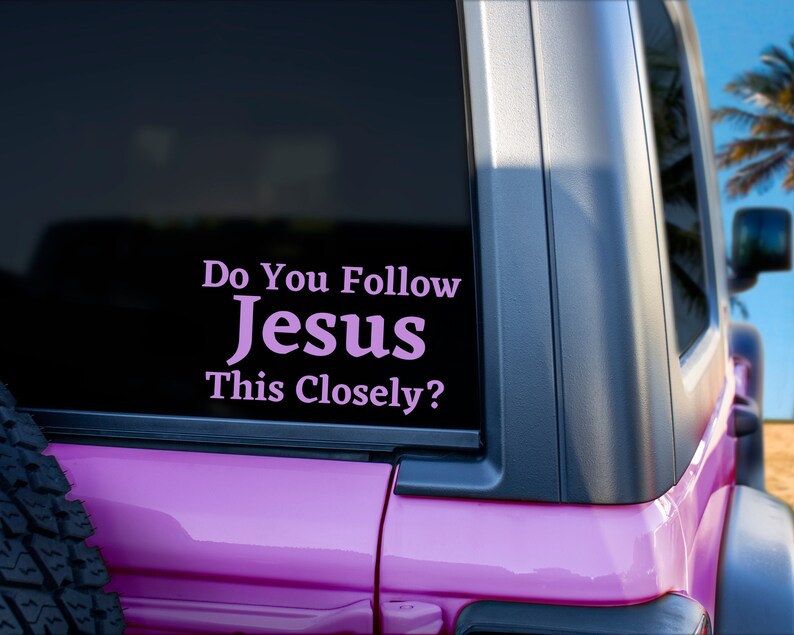 May include: A pink Jeep with a sticker on the back window that reads "Do You Follow Jesus This Closely?"