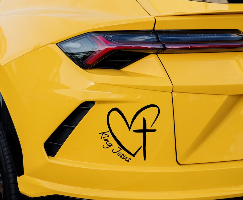 May include: A yellow car with a black heart and cross decal that says "King Jesus".