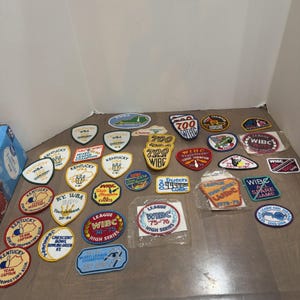 Könnte beinhalten: Eine Sammlung bestickter Bowling-Aufnäher in verschiedenen Formen und Farben. Die Aufnäher zeigen Texte wie Kentucky WBA, WIBC League Champion, 700 Series und All Spare Game sowie Grafiken von Bowling-Pins und Bowlingkugeln.