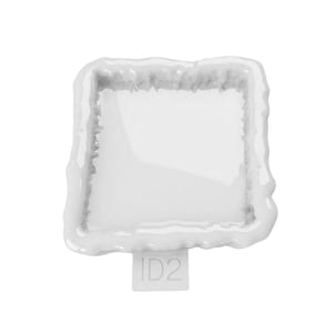Peut inclure: Un moule en silicone blanc présentant une cavité de forme carrée avec une bordure irrégulière et texturée. Le moule possède une petite languette rectangulaire dépassant du bord inférieur, marquée du texte alphanumérique ID2 en blanc.