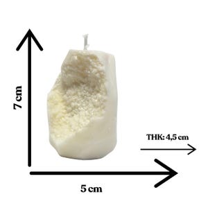 Op de afbeelding: Witte kaars met een ruw, getextureerd oppervlak. De kaars is 7 cm hoog en 5 cm breed. THK: 4,5 cm