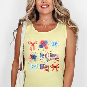 May include: A yellow sleeveless tank top with a graphic print of red, white, and blue bows, fireworks, and American flags.