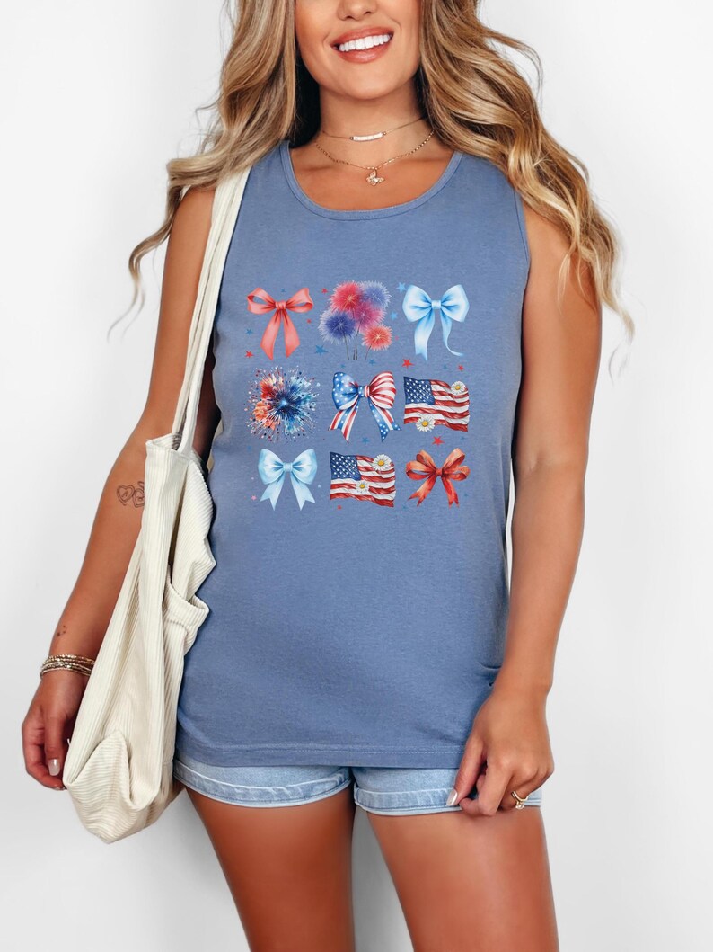 May include: A blue sleeveless tank top with a graphic print of red, white, and blue bows, fireworks, and American flags.