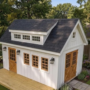 May include: A white shed with vertical siding, a dark gray shingled roof, and a dormer window. It features natural wood-toned doors with glass panes, multiple windows, and black exterior wall-mounted lanterns on the front and side walls.