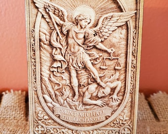 May include: A rectangular wooden plaque featuring a laser-engraved depiction of Saint Michael the Archangel defeating a figure. The detailed artwork includes wings, a sword, and scales, with the text SAINT MICHAEL THE ARCHANGEL at the bottom.
