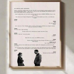 May include: A framed print with a scene from a film, featuring a man and a girl in a black and white image. The print also includes a script with text. The frame is a light brown colour.