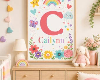 May include: A framed wall art print featuring a large coral letter C and the name Cailynn in multicolored text. The design includes a rainbow, a smiling yellow star, a purple butterfly, a blue cloud with hanging hearts, and various colorful flowers.