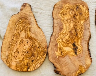 Puede incluir: Cuatro tablas de cortar de madera natural con patrones de veta únicos. Las tablas son de varios tamaños y formas, con un aspecto rústico y orgánico.