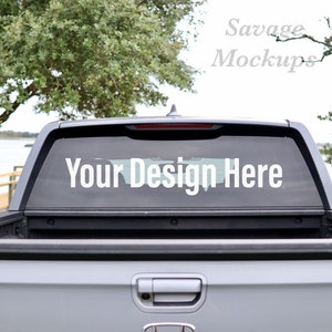May include: A gray pickup truck with a black tailgate and a rear window with the text "Your Design Here" in white.