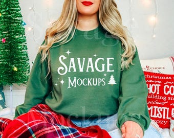 May include: A green sweatshirt with the text "SAVAGE MOCKUPS" in white lettering. The sweatshirt is being worn by a person sitting on a red and black plaid blanket.